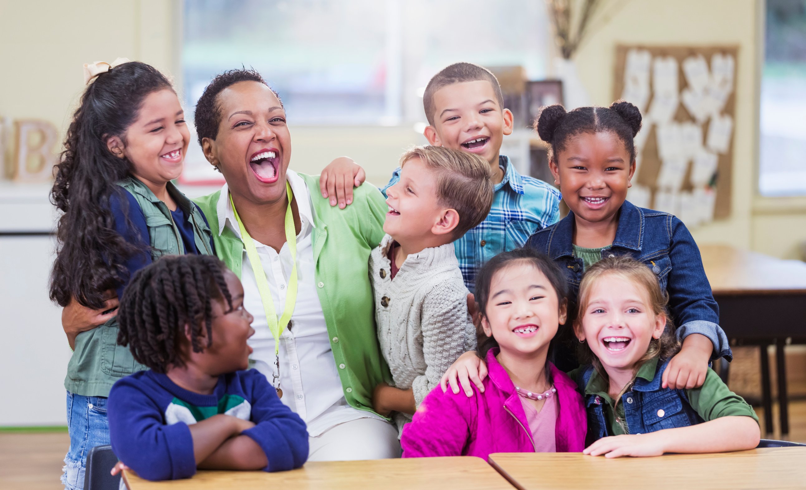 Teacher and elementary school students, fun in classroom